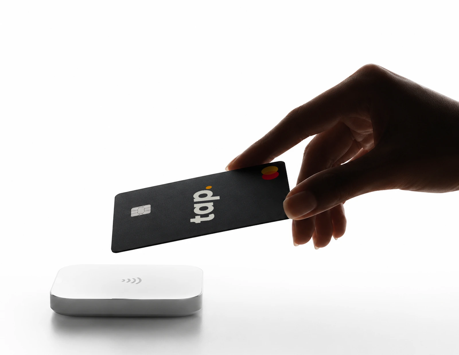 Hand holding a Tap card over a contactless payment terminal